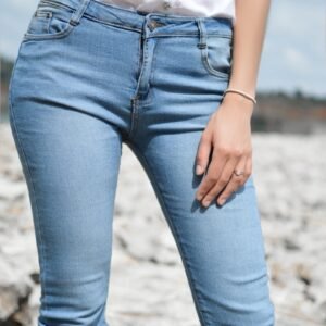 woman standing wearing jeans and white top